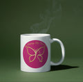 White mug with pink butterfly design on a green background